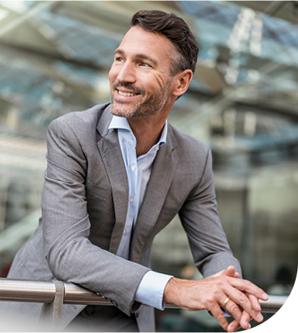 smiling business man leaning on a railing in a building