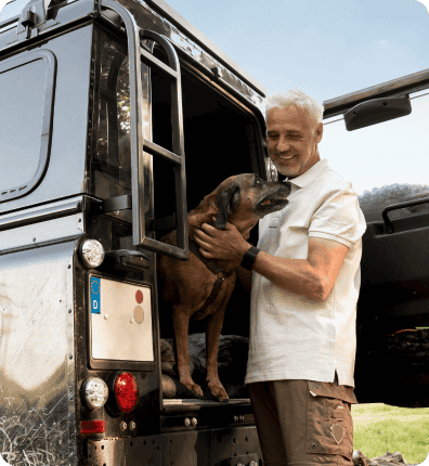 Man petting dog back of his suv